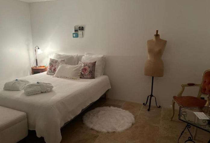 a bedroom with a bed with a white bedspread and a dresser at Maison 1838 