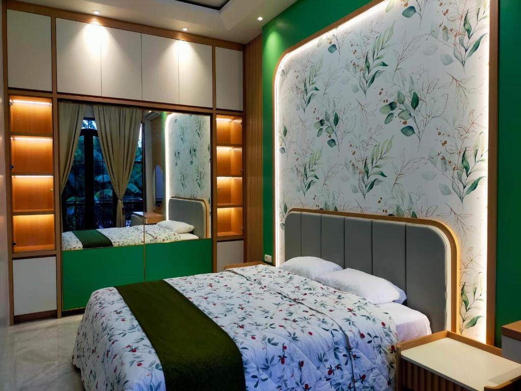 a bedroom with a large bed and a mirror at Guest House Adiwinoto in Mantaak