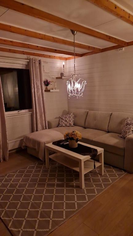 a living room with a couch and a table at Apartment in peacefull surroundings in Ådnavik