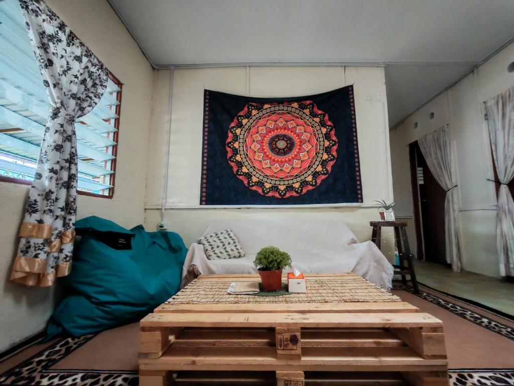 a living room with a wooden table and a rug at Fantasy Stay Cameron Highlands in Kampung Kuala Terla