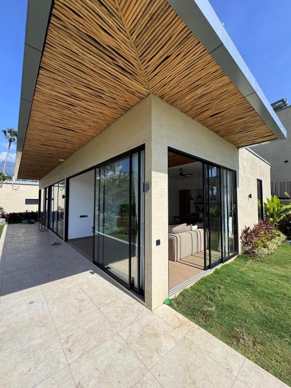 a house with glass doors and a wooden ceiling at Julim Flora - Eco Villa in Amed
