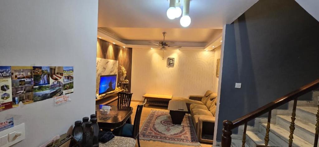Una sala de estar con un sofá y un televisor. en T&J Villa Mussoorie, en Mussoorie