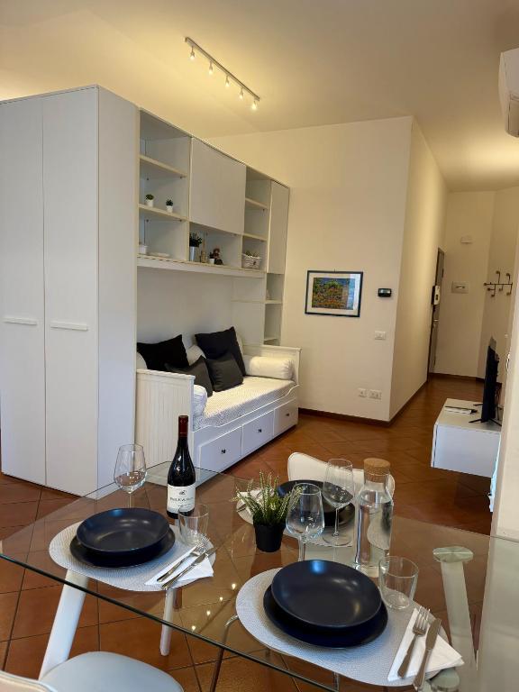 una sala de estar con una mesa de cristal con platos y copas de vino en Vicenza Charm Apartment, en Vicenza