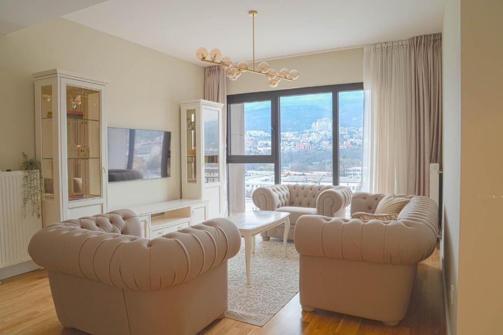 ein Wohnzimmer mit Sofas und einem Tisch und Stühlen in der Unterkunft Limak's Diamond Residences in Skopje
