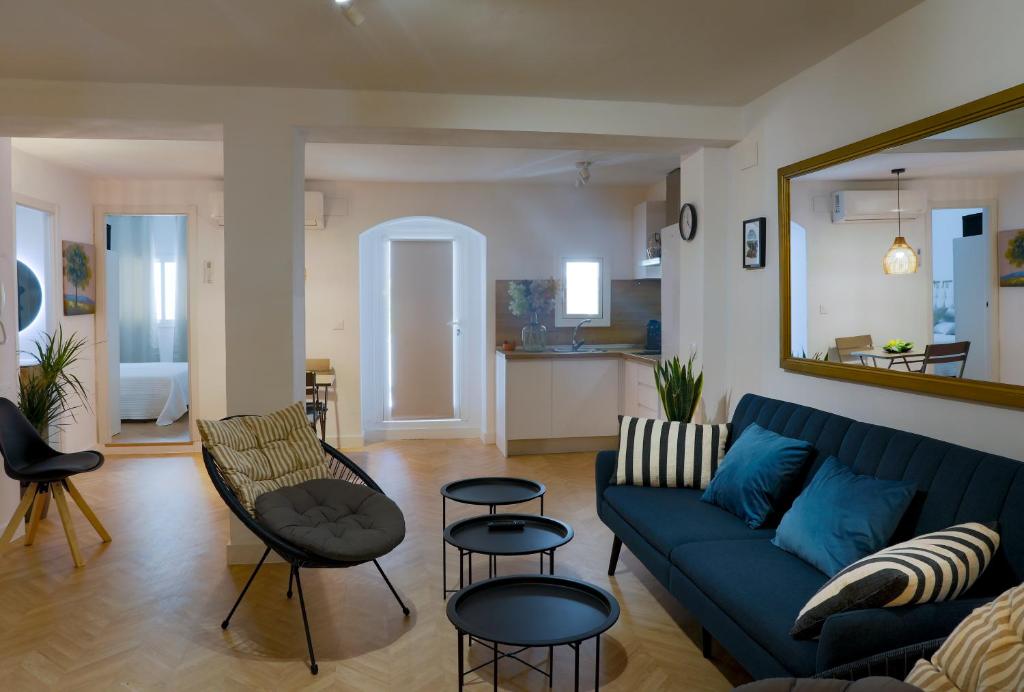 a living room with a blue couch and chairs at La Casa del Gallo Alojamientos by Taberna Bolero in Montilla