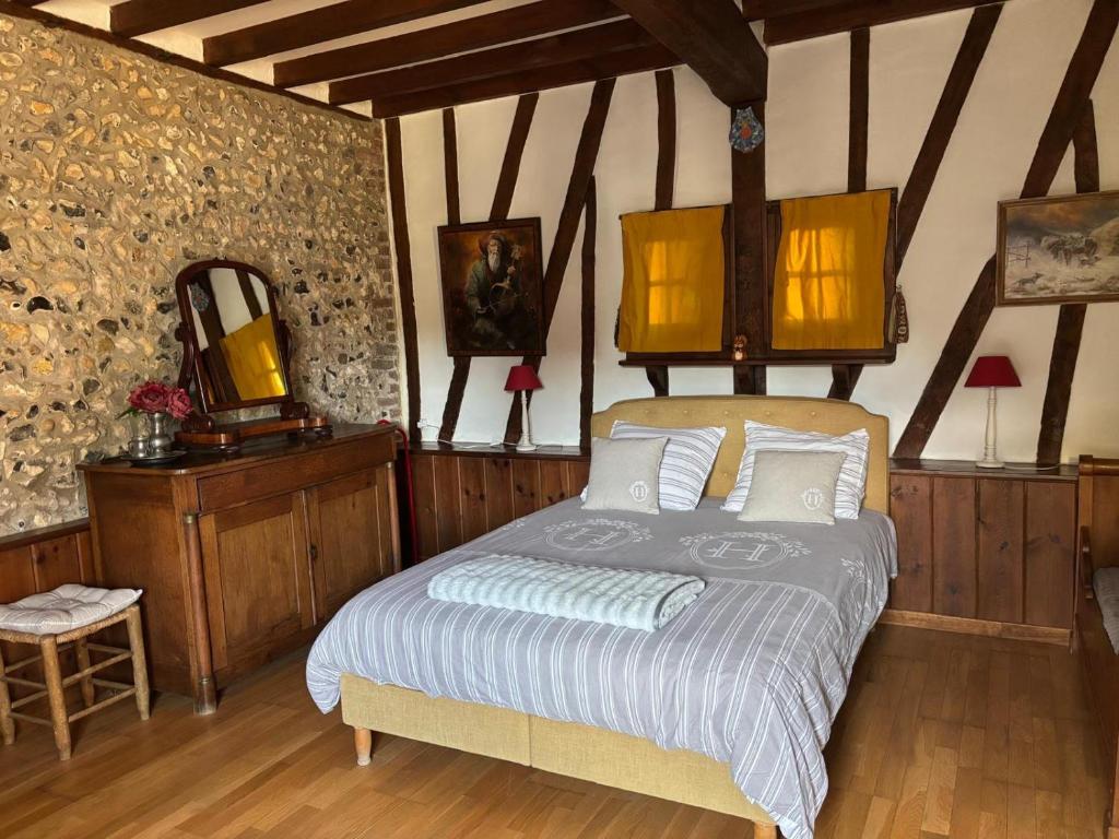 una camera da letto con un letto in una stanza con pareti in legno di Les Côtières a Maresville