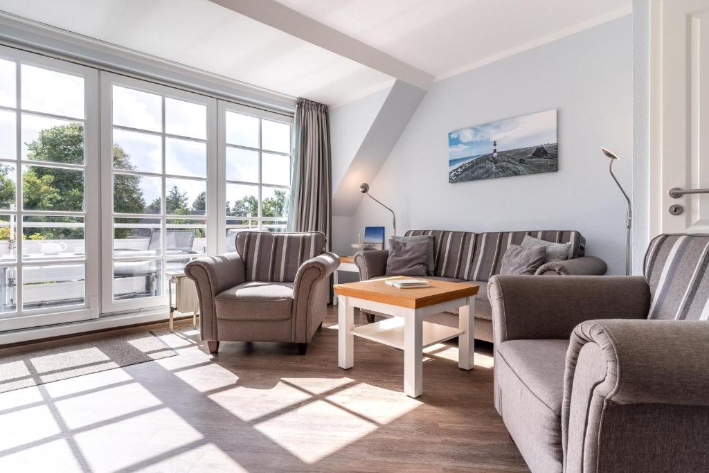 a living room with two couches and a table at Rungholt in Ording