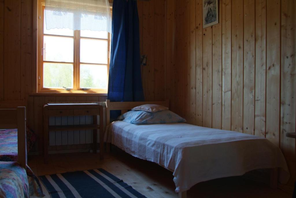 a small bedroom with a bed and a window at Stajnia Okliny in Wiżajny