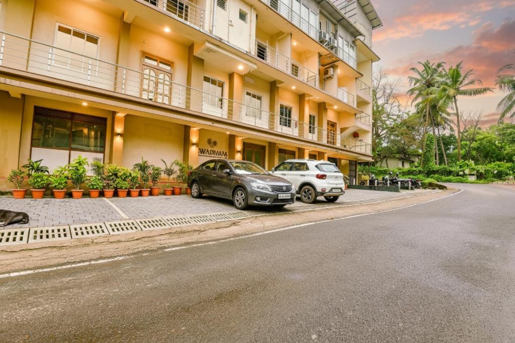 two cars parked in front of a building at Swarnam Hotel in Old Goa