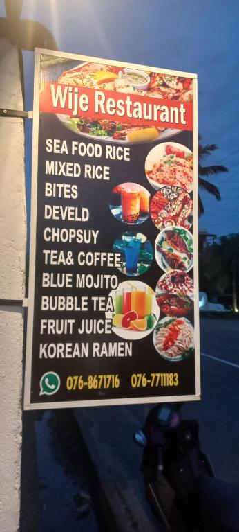 Un cartel en el lateral de un edificio con un menú. en Wije House, en Dikwella