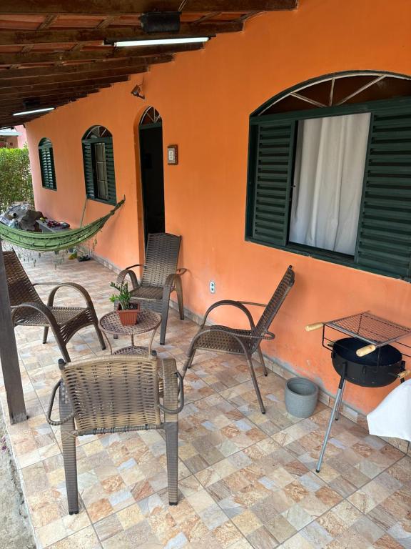 a patio with chairs and a table and a grill at Chalé Arco Iris in Esmeraldas