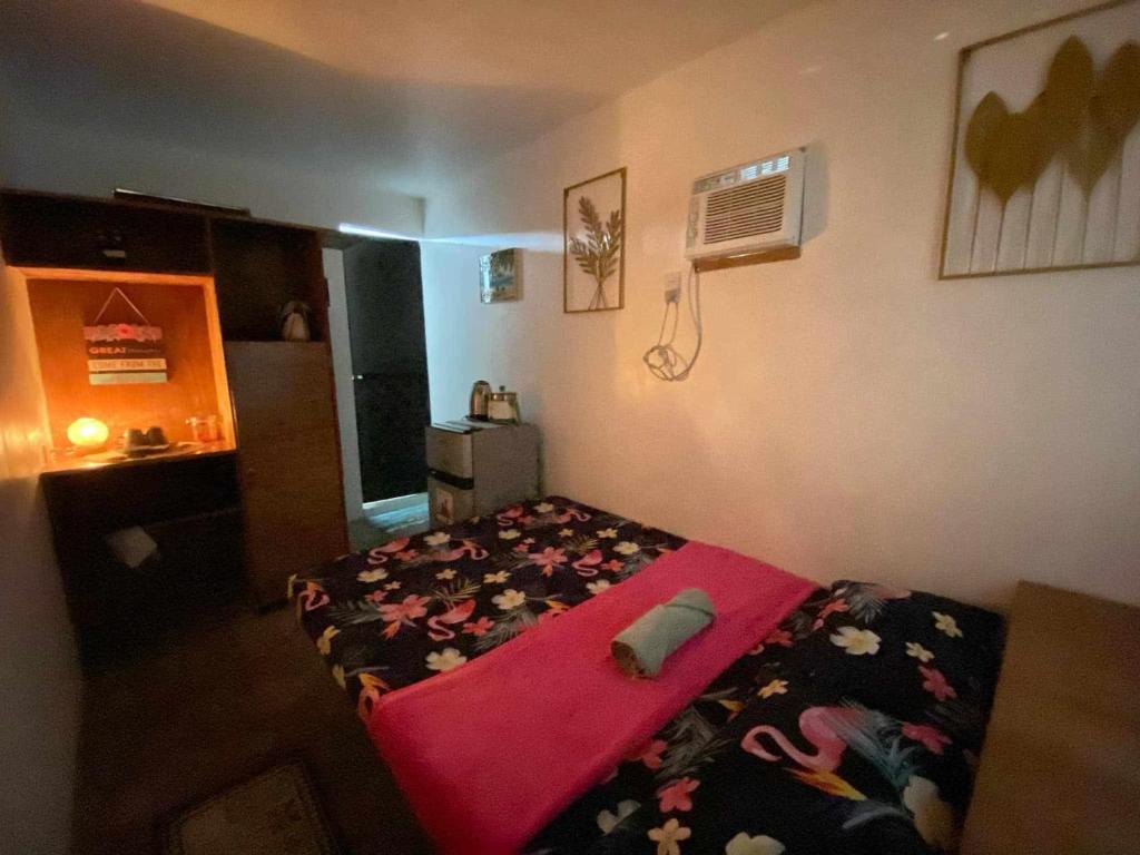 a bedroom with a bed and a air conditioner at Honu Homestay Siargao in Sampong