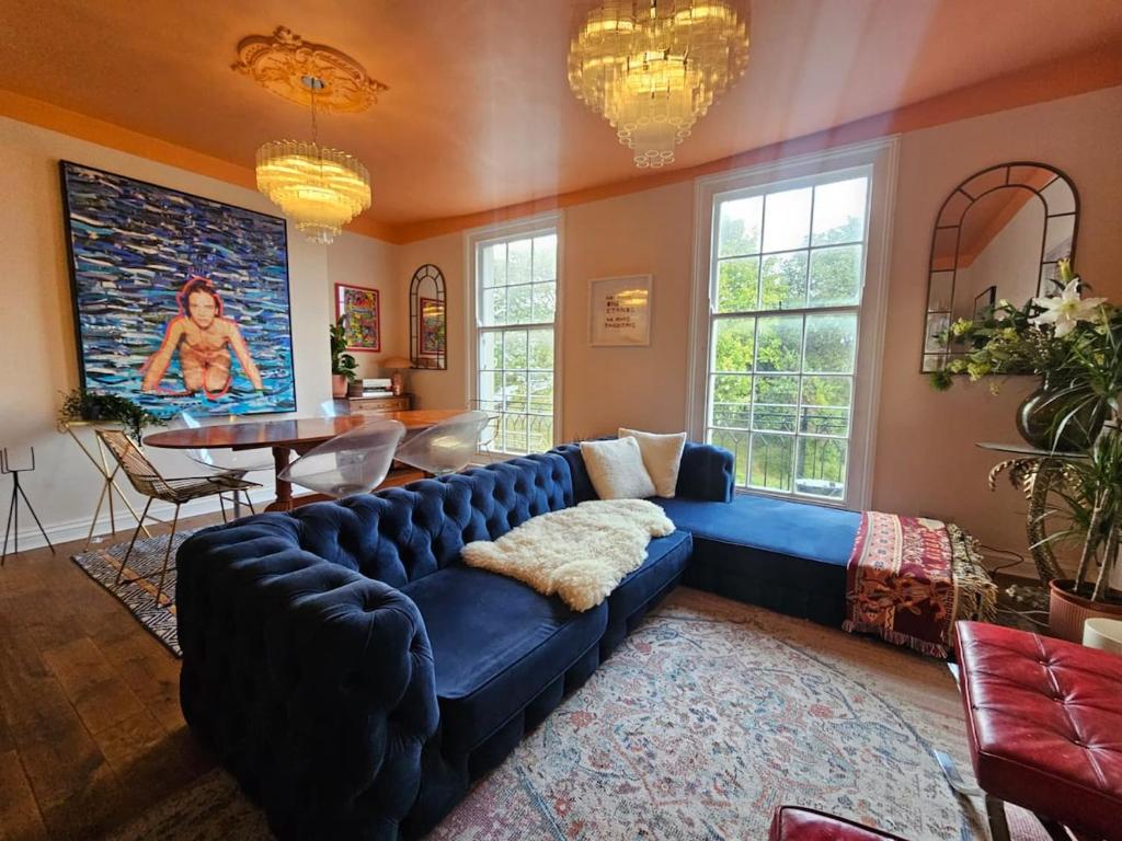 a living room with a blue couch and a table at Georgian Townhouse-Old Town Margate-Sleeps 6 in Margate