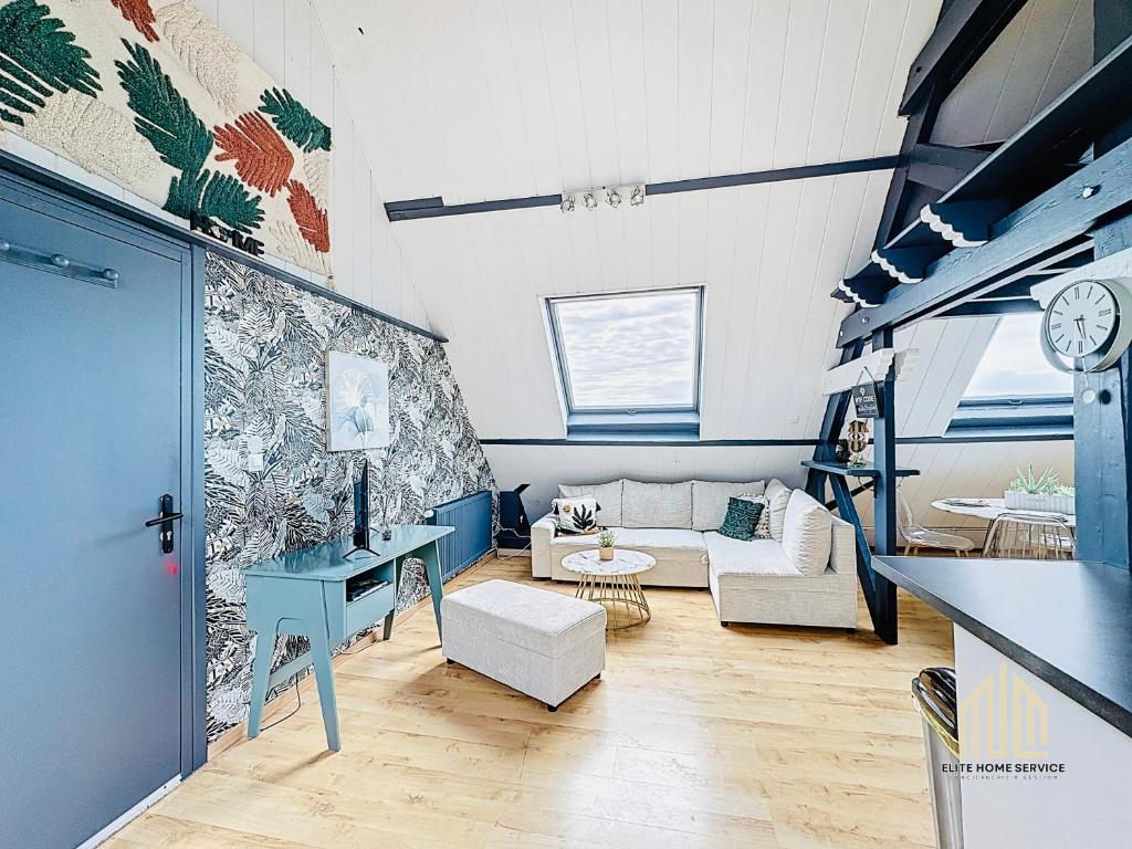 ブレ・デューンにあるSuite Léonard - Prestige et détenteのソファと壁掛け時計のあるリビングルーム