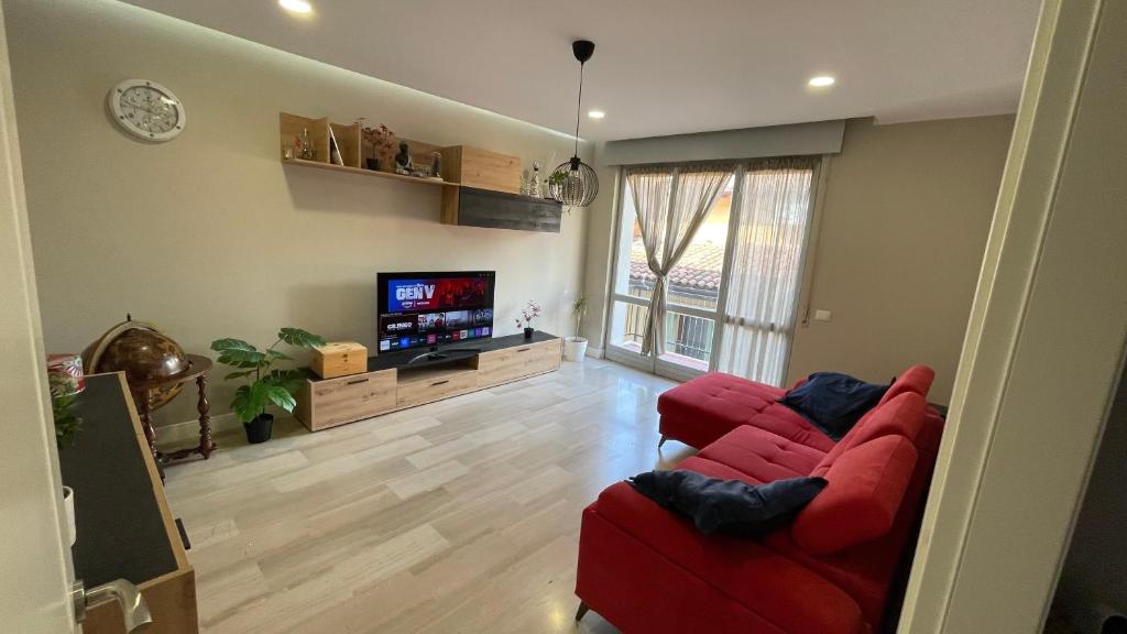 a living room with a red couch and a flat screen tv at Borgo Trento Residence - Vista Monte Grappa in Verona