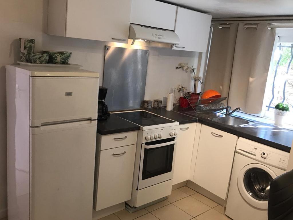 La cuisine est équipée d'une cuisinière, d'un évier et d'un lave-vaisselle. dans l'établissement Appartement en rez de villa, à Montpellier