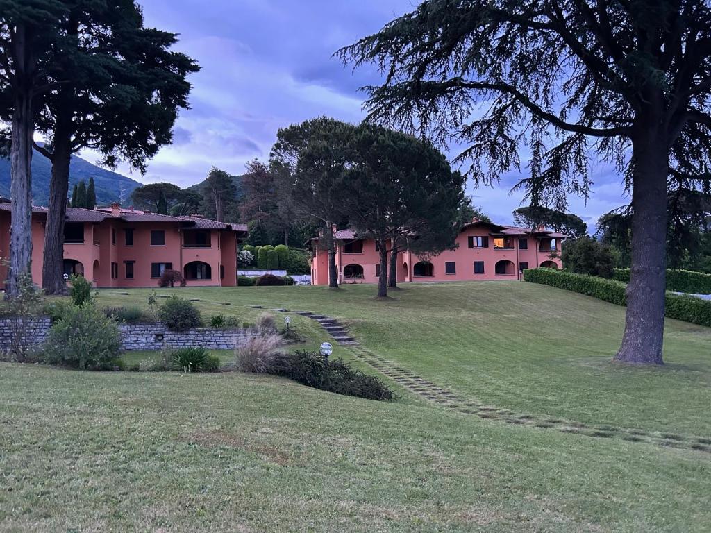 a view of a house with a lawn and trees at Colonia del Lago - Trilocale - Menaggio in Menaggio