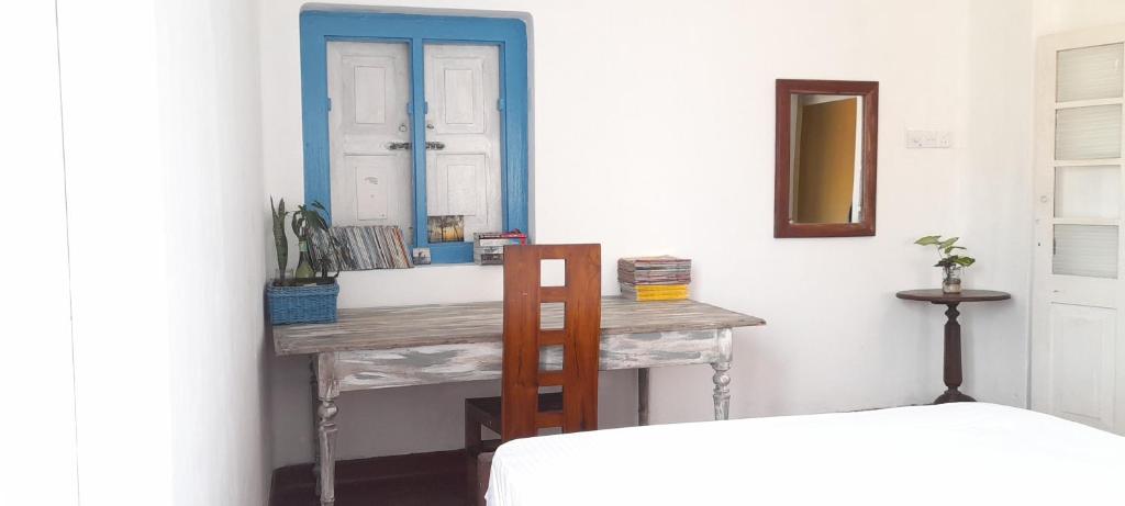 een slaapkamer met een bureau met een spiegel en een bed bij Ocean breeze in Galle
