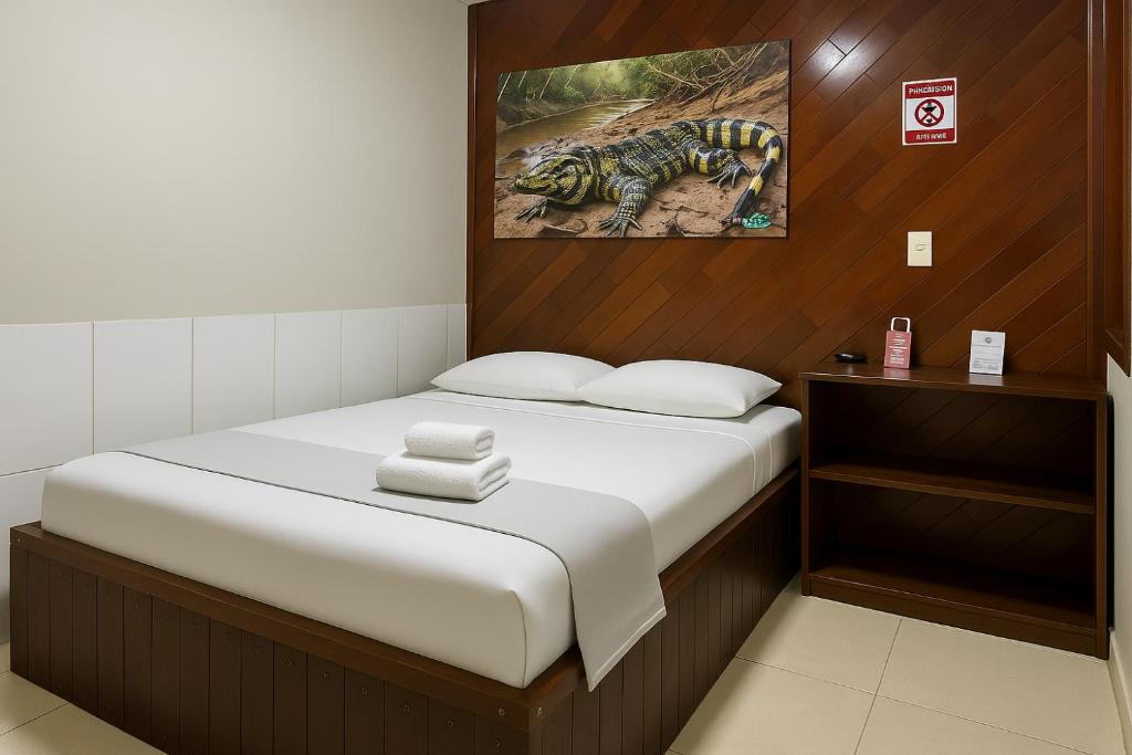 a bed in a room with a picture of a bug at Hotel COP 30 in Belém