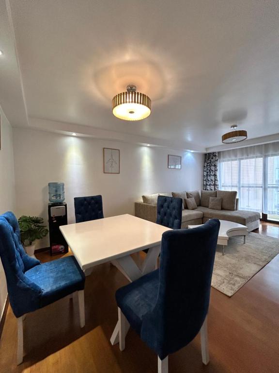 a living room with a table and chairs and a couch at The Alma Luxe Modern 1 bedroom Apartment in Ruaka