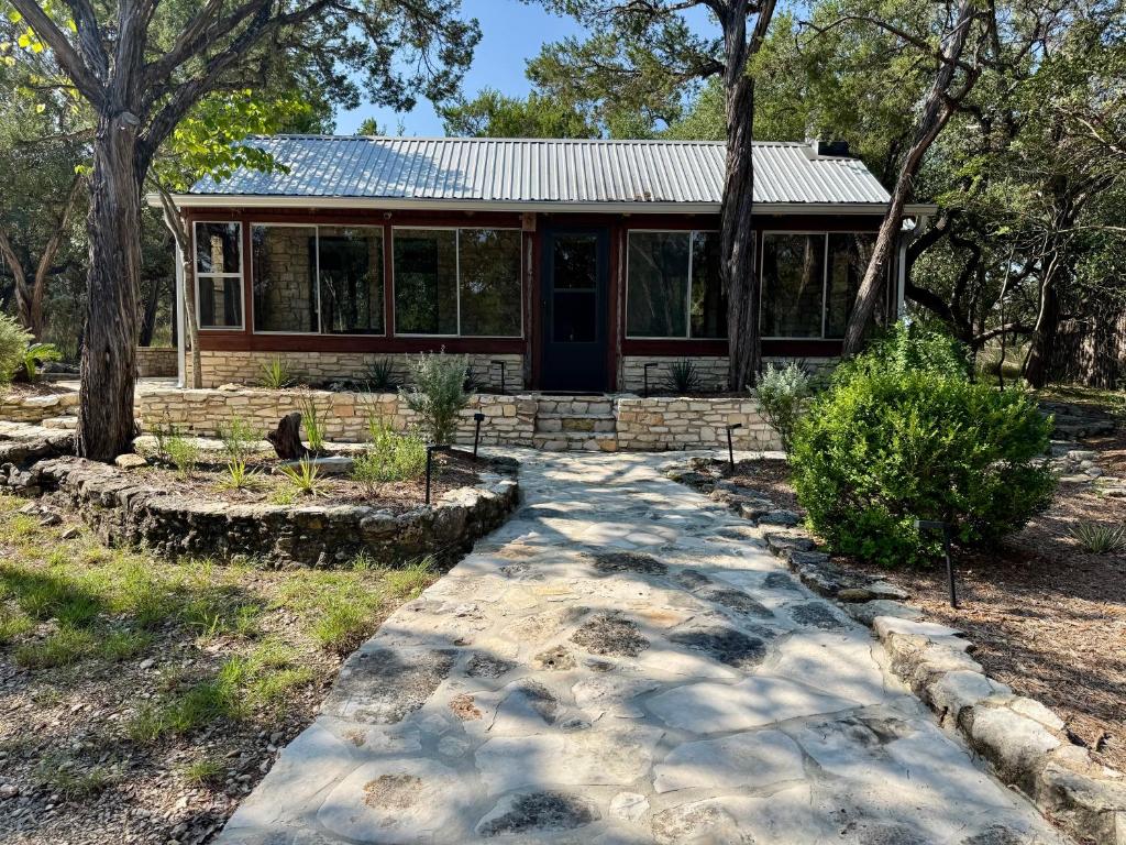 une maison avec un chemin devant elle dans l'établissement Charming Blanco Riverfront Cottage, à Wimberley