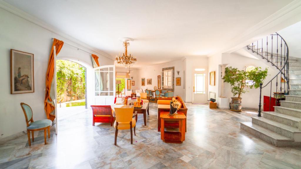a living room filled with furniture and a staircase at Authentique Villa Tunisoise avec Piscine à Marsa in Dar Tahar Zaouch