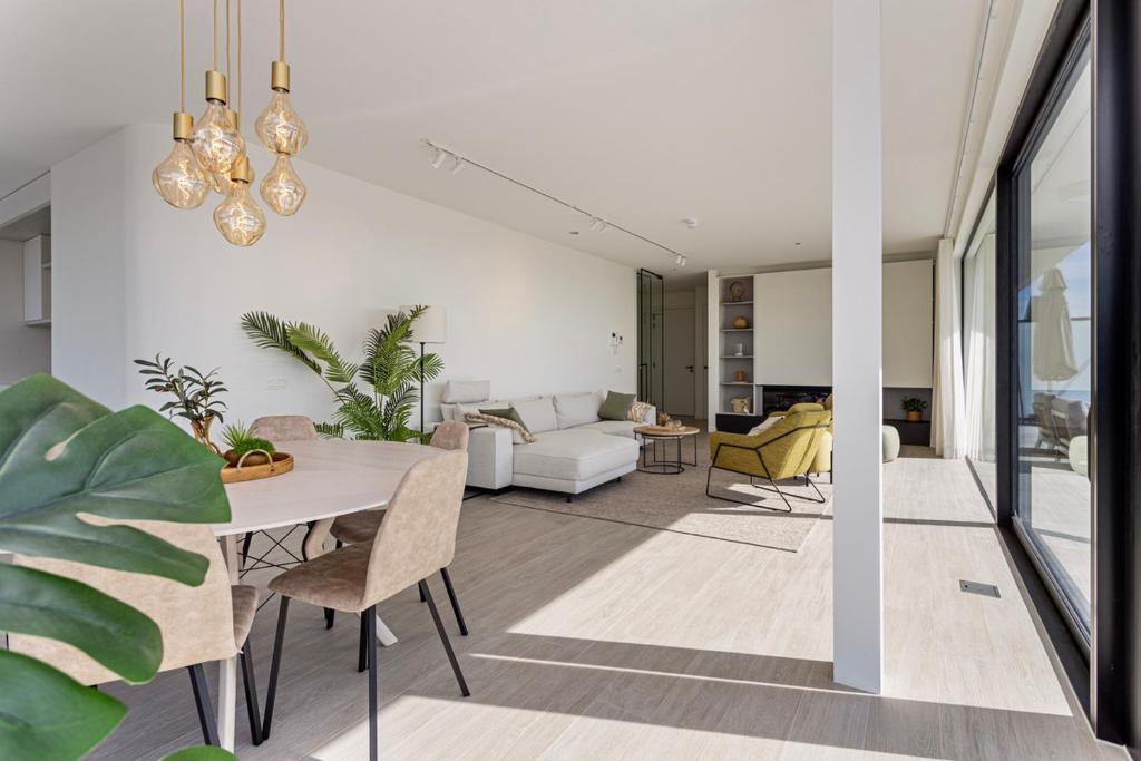a living room with a table and a couch at Faro Greenpark, Cadzand-Bad Penthouse in Cadzand
