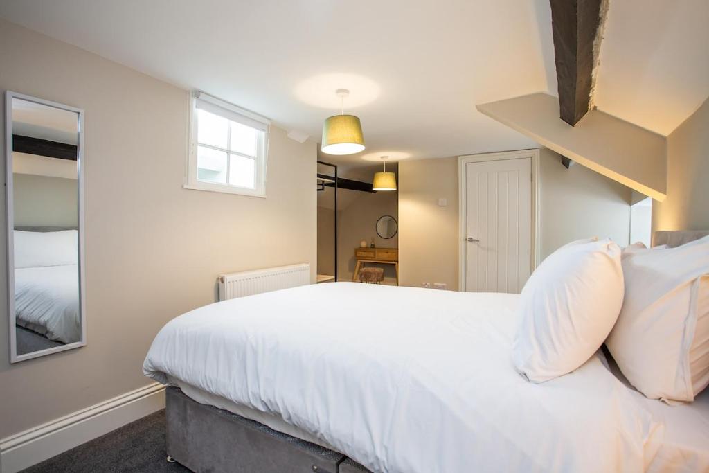 une chambre avec un grand lit blanc et une fenêtre dans l'établissement Livingston Retreat 4bed Home Wi-Fi Parking, à Uphall
