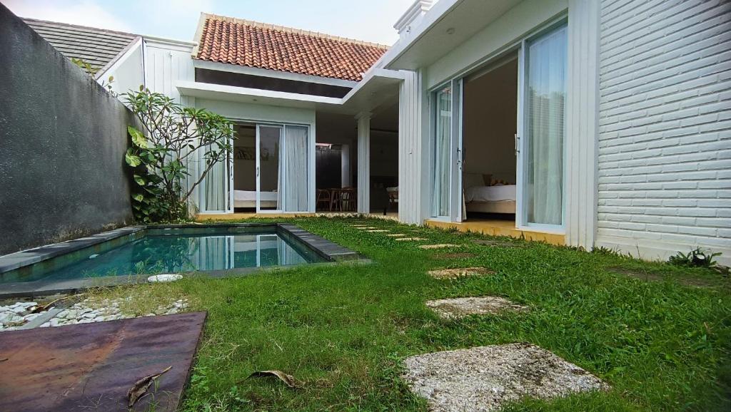 einen Hinterhof mit Pool neben einem Haus in der Unterkunft D'Villa in Uluwatu