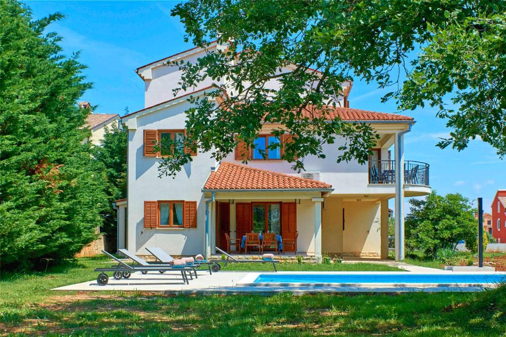 a house with a pool in front of it at Villa Theresa in Ližnjan (Haus für 12 Personen) in Ližnjan