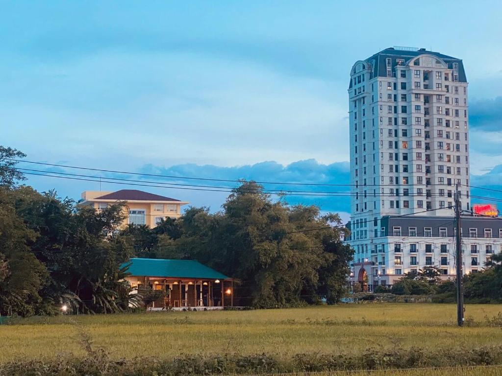 a tall building with a gazebo in a field at Ruộng Homestay Nguyên căn 5 phòng ngủ in Thôn Trường Giang