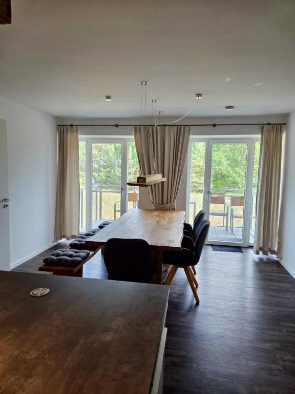 a living room with a table and chairs and windows at Ferienwohnung Treibholz in Binz