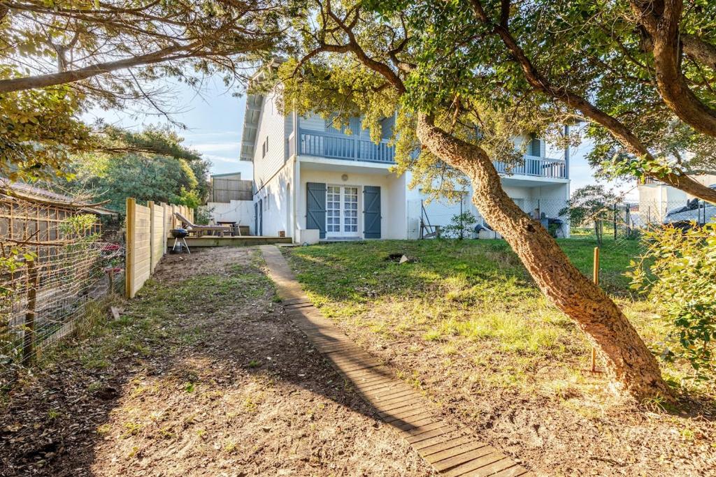 ein Baum vor einem weißen Haus in der Unterkunft T3 Les Anémones à 50m de la plage avec grande terrasse et grand jardin in Soorts-Hossegor
