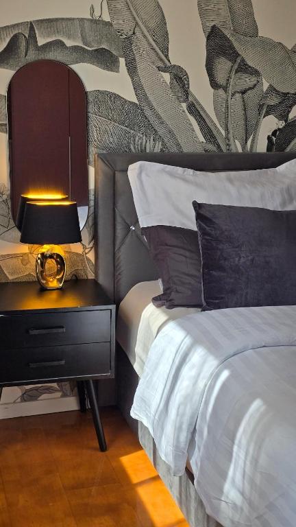 a bedroom with a bed and a nightstand with a lamp at Apartment am Waldrand mit Einzelgarage, Nähe City, Messe & Flughafen in Leinfelden-Echterdingen