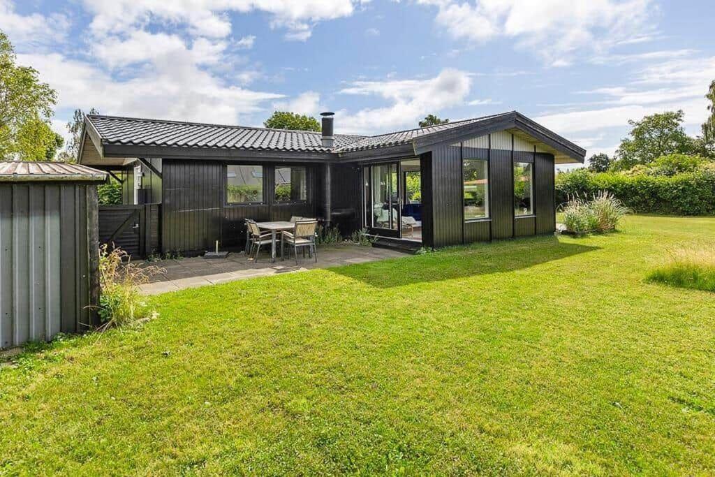 a black house with a table in a yard at SB116-Sydals-Birkemose-29 in Skovbyballe