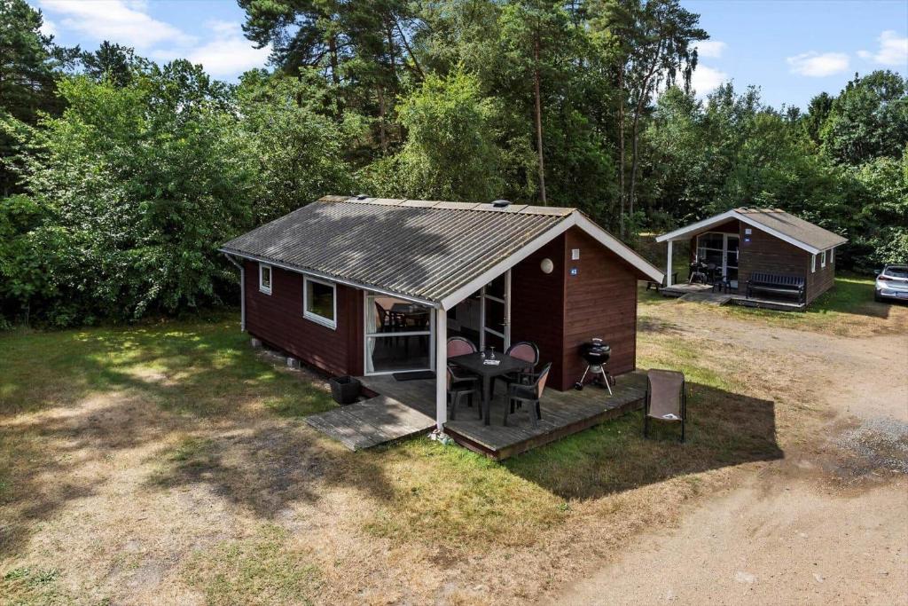 Una pequeña cabaña con una mesa y sillas en un patio. en 3715-Nexo-Klynevej-42, en Snogebæk