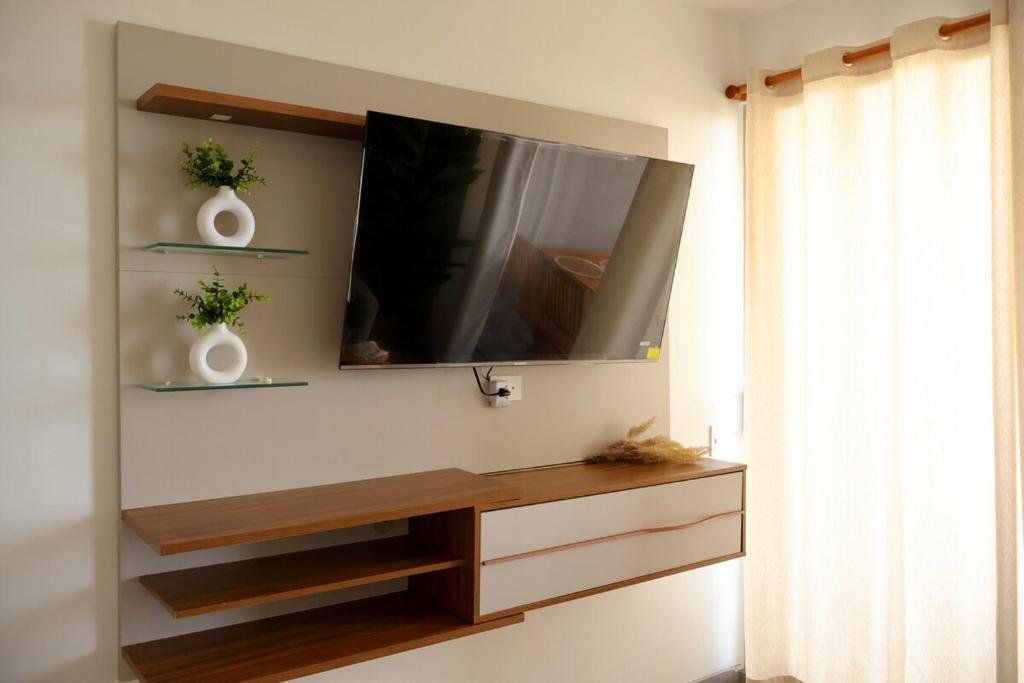 a living room with a tv on a wall at Modern apartment with direct ocean view in Simón Bolivar