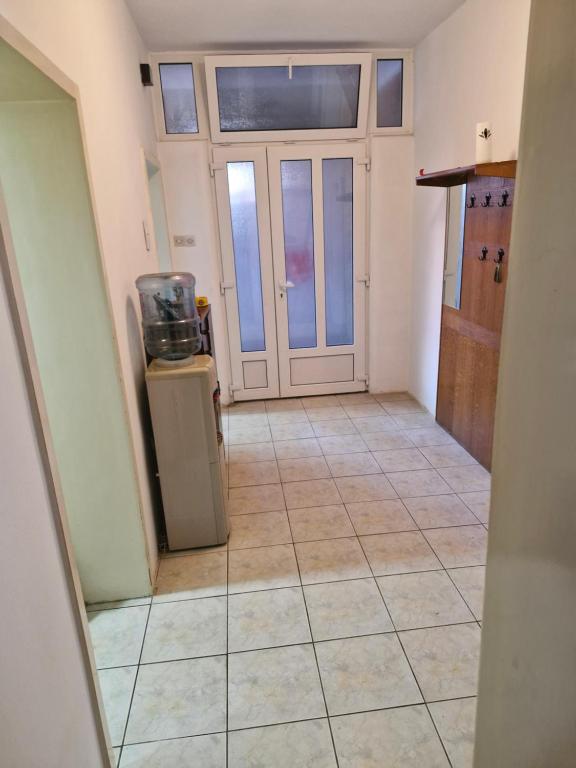 an empty room with a door and a tiled floor at DiS Apartman in Vršac