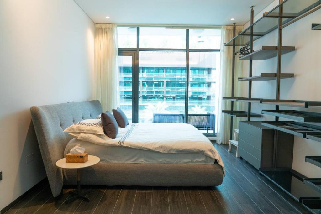 a bedroom with a bed and a table and a window at Hive Stayz - 1 Bedroom Canal Harbor Row in Manama