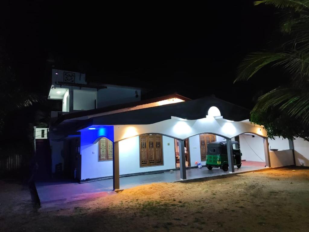 a white house at night with a blue light at TR Rest House in Trincomalee