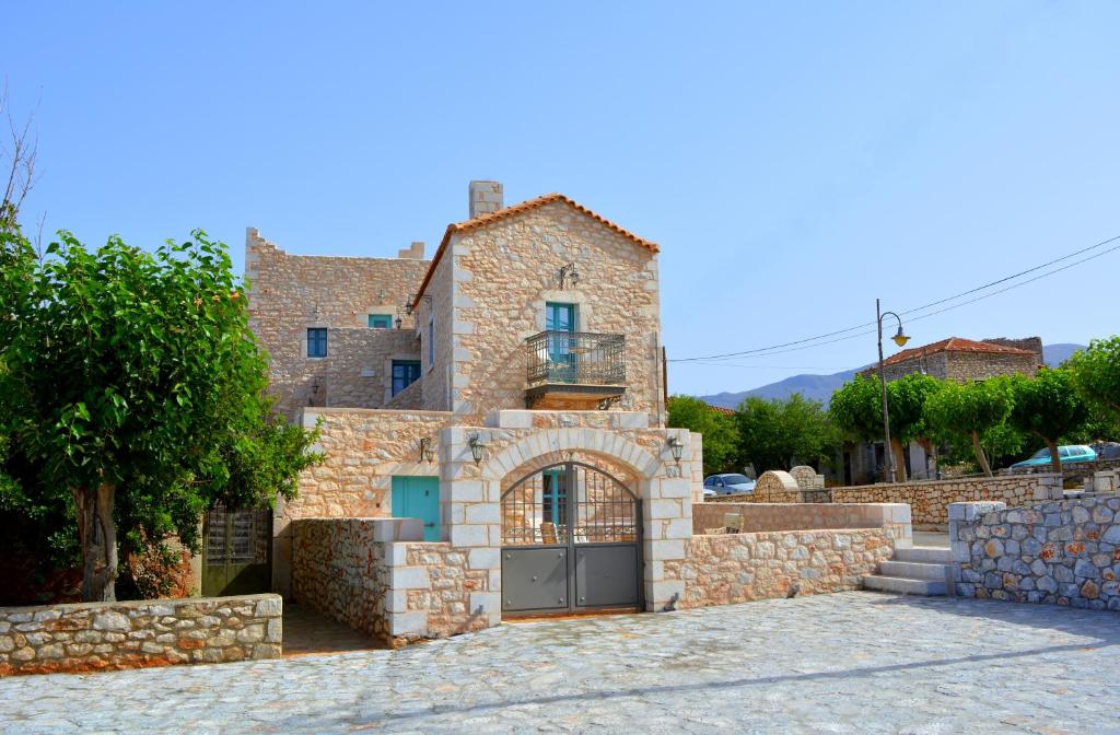 a stone house with a gate and a stone wall at Olea in Pirgos Dhirou