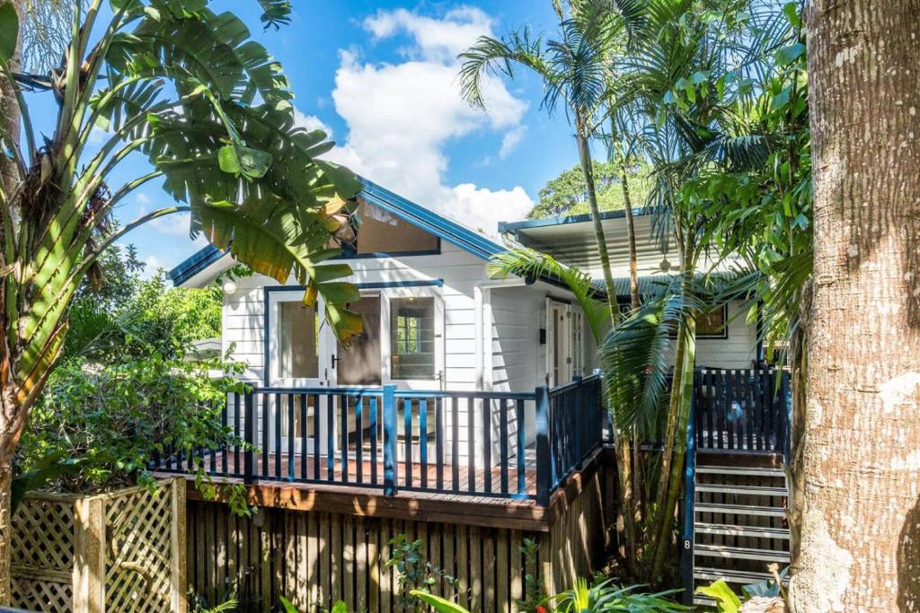 una casa bianca con una recinzione e palme di Broadviews Secret Hideaway a Brunswick Heads