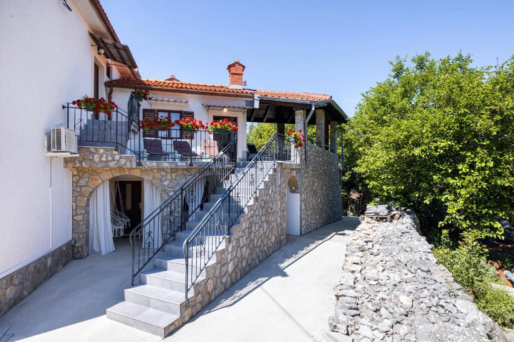 ein Haus mit Treppen und Blumenkästen darauf in der Unterkunft Lorenzo in Klanice (Haus 2 für 6 Personen) in Dobrinj