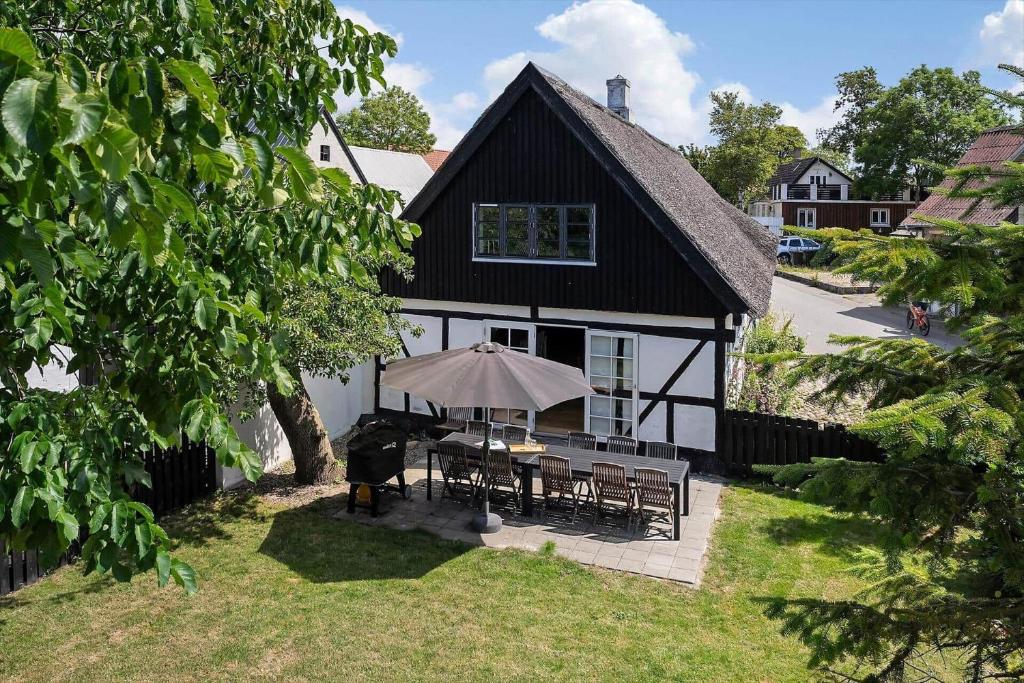 una casa bianca e nera con un tavolo con un ombrellone di 20621-Brundby-Trekanten-12 a Brundby