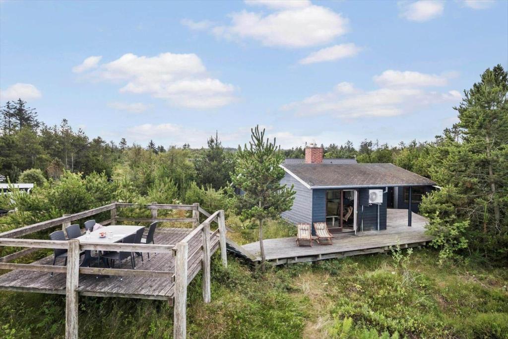 een klein huisje in het bos met een terras bij JB363-Fjerritslev-Tolderstien-8 in Torup Strand
