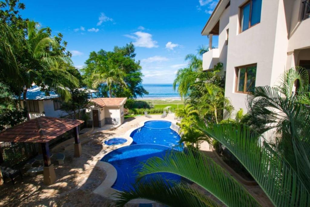 una imagen de una piscina frente a un edificio en Sol Y Mar 3b Beachfront 3br Condo Playa Hermosa, en Playa Hermosa