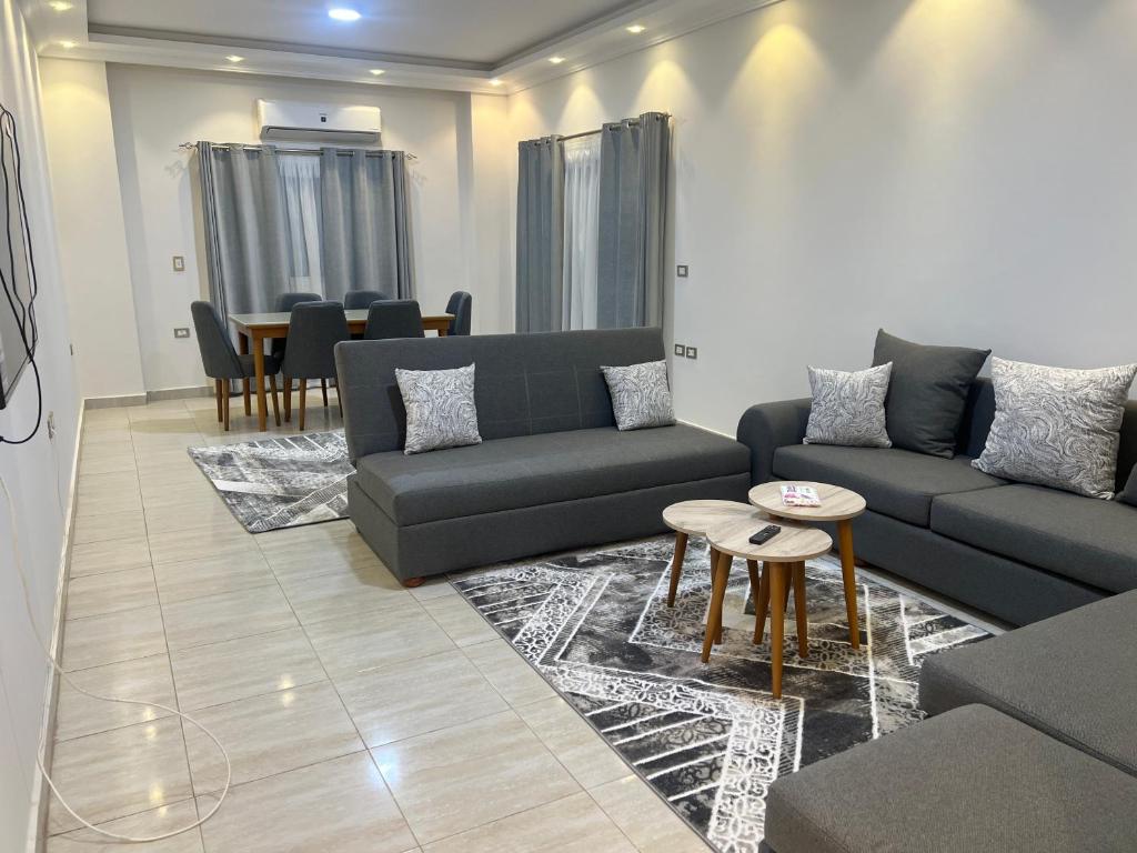 a living room with couches and a table and chairs at Elite House الصفوة للشقق الفندقية in 6th Of October