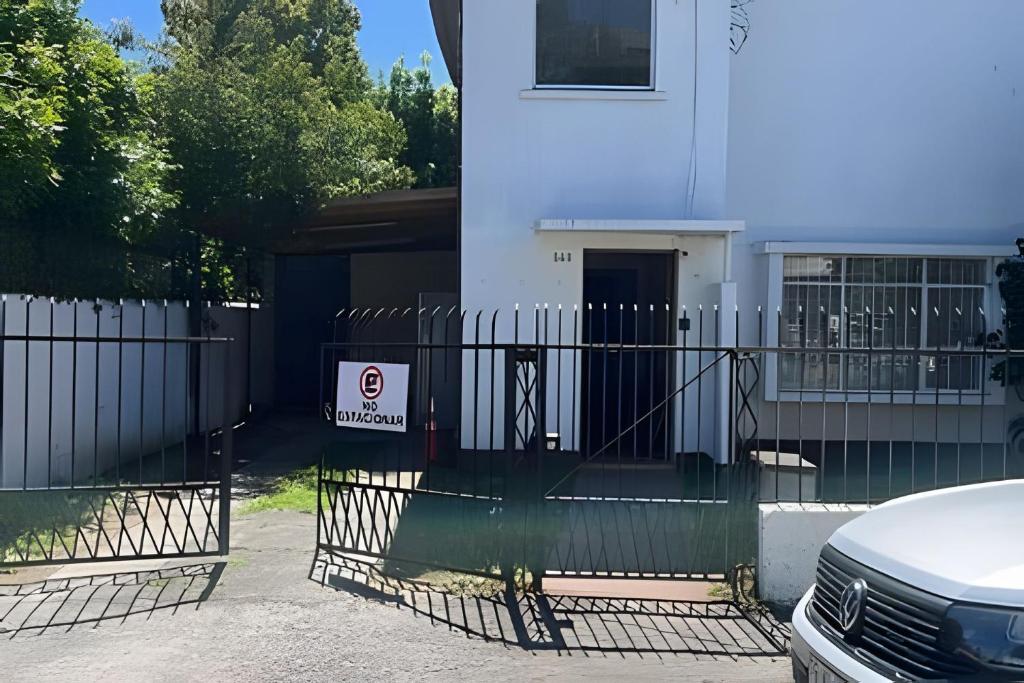 a gate in front of a house with a sign on it at Habitación 2 a 3 pers. in Temuco