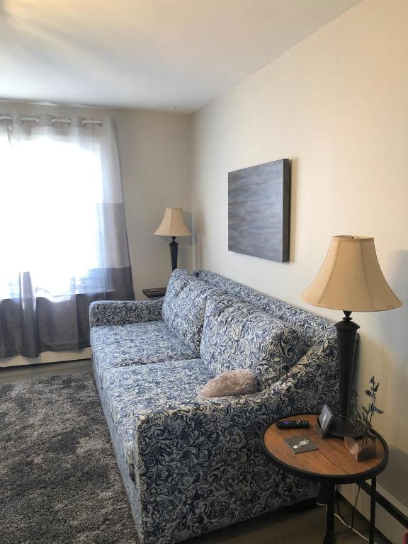 a living room with a couch and a table with a lamp at Mariners Nest in Saint John