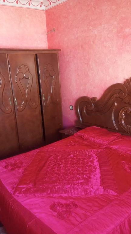 a pink bedroom with a bed with a red bedspread at Tetouan city in Tétouan
